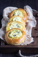 Fresh homemade open patties with cottage cheese and raisins. Traditional Russian yeast pastry vatrushka, round buns, curd tart. Buns with cottage cheese and raisins. Rustic style. Copy space.