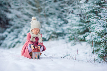 Back view of adorable girl with flashlight on Christmas outdoors