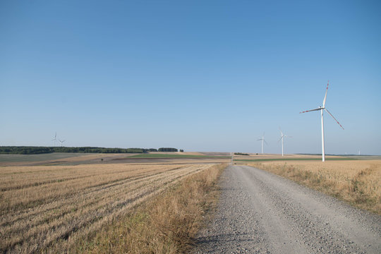 droga wśr&oacute;d p&oacute;l z wiatrkami