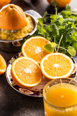 Fototapeta na wymiar Fresh oranges juicer juice tropical fruits and herbs on concrete board