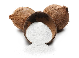 Pile of shredded coconut meat in half shell isolated on white background