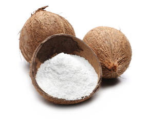 Pile of shredded coconut meat in half shell isolated on white background