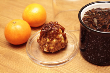 Tangerin, baked goods and a cup of tea on a wooden board