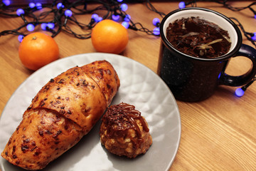 Christmas. garland, pastries and a cup of tea on a wooden board