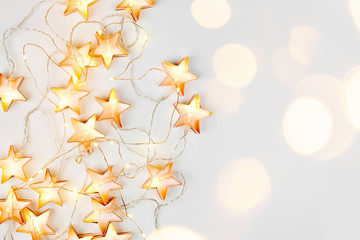 Warm star-shaped light garlands, festive decorations with copy space.  Christmas concept. Flat lay,...