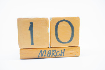 march 10th. Day 10 of month, handmade wood calendar isolated on white background. Spring month, day of the year concept.