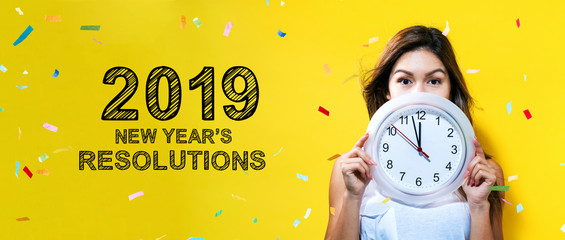 2019 New Years Resolutions with young woman holding a clock showing nearly 12