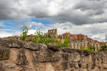 Beautiful overcast partial Viana urban skyline as seen over an old stone fence, the ruins of the Church of San Pedro in the distance, the Way of St. James, Camino de Santiago in Navarre, Spain