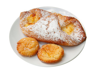 Sweet buns sprinkled with powdered sugar on a white plate