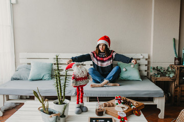 .Sweet and cheerful woman enjoying christmas at her home. Wearing christmas costume, having fun and...