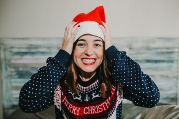 Obraz premium .Sweet and cheerful woman enjoying christmas at her home. Wearing christmas costume, singing, screaming and having fun. Lifestyle. Season photography.