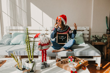 .Sweet and cheerful woman enjoying christmas at her home. Wearing christmas costume, having fun,...