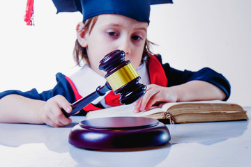Humorous photo of serious child girl judge (lawyer) makes a decision.