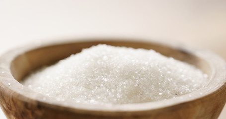 Fototapeta na wymiar Closeup of white sugar in wood bowl on wooden table