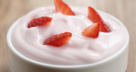 Closeup of organic strawberry yogurt on wooden table