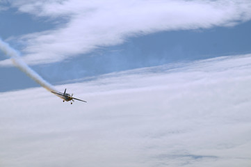 Fototapeta na wymiar Air show. Plane with a trace of smoke during a diving flight.