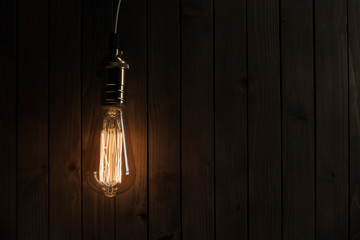 The light bulb illuminates on wooden background
