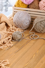Woolen yarn and fabric on the window sill. Beautiful view outside the window - winter scenery and snow.