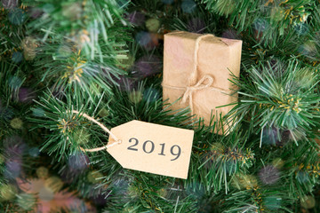 Gift box and tag with text "2019" on christmas tree