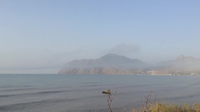 Calm Black Sea And Mountain Qara Dag Karadag Covered With Smoke - Crimea Russia