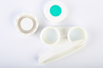 Contact lens, contact lens case, tweezers on white background. Correction of vision.
