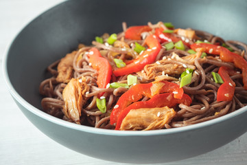 Dark pasta with steamed vegetables and grilled chicken. Delicious buckwheat noodles with vegetables and chicken