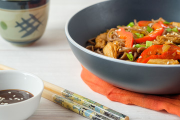 Dark pasta with steamed vegetables and grilled chicken. Delicious buckwheat noodles with vegetables and chicken