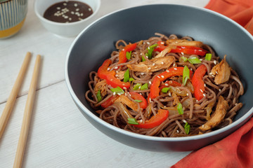 Dark pasta with steamed vegetables and grilled chicken. Delicious buckwheat noodles with vegetables and chicken