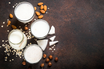 Obraz na płótnie Canvas Vegan non dairy alternative milk, nuts and oat milk top view. 