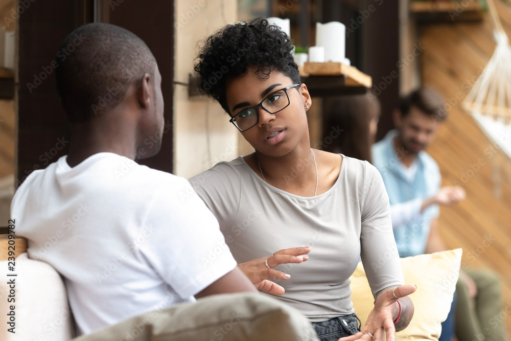 Wall mural focused african american woman talking with man in cafe, girlfriend discussing relationships with bo