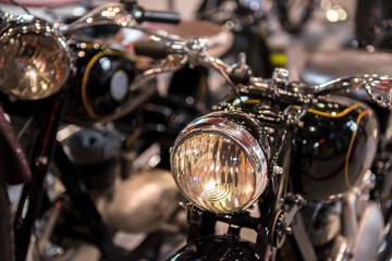 Retro motorcycle with headlight on blurred background