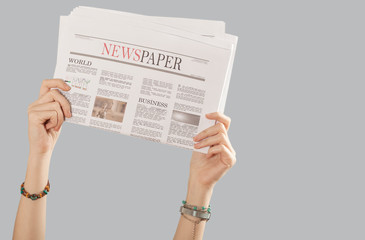 arm raised holding newspaper