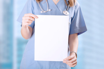 Doctor woman showing empty pages at clinic - obrazy, fototapety, plakaty