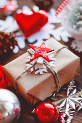 Christmas and New Year background with presents, ribbons, balls and different decorations on wooden background. Gift with red star symbol.