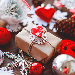 Christmas and New Year background with presents, ribbons, balls and different decorations on wooden background. Gift with toy heart, symbol of love.