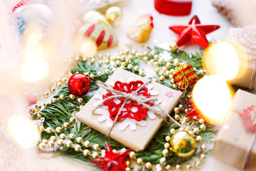 Christmas and New Year background with thuja branch, decorations and presents wrapped in craft paper with snowflakes.