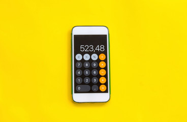 smart phone with calculator on yellow background - obrazy, fototapety, plakaty