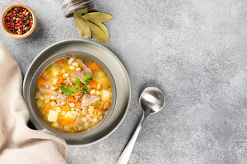 Rassolnik - Traditional Russian soup with pickled cucmbers, pearl barley, meat, pickles, carrots and potatoes  on light background. Top view