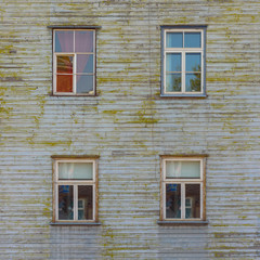 Fototapeta na wymiar Facade of old brown wooden house with four windows