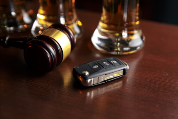 Drinking and driving concept. Car key on a wooden table, pub background
