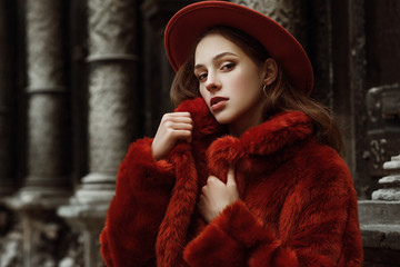 Outdoor close up fashion portrait of young beautiful confident woman wearing trendy orange faux fur...
