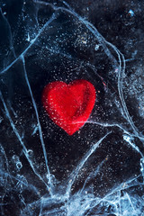 frozen red heart in blured ice.