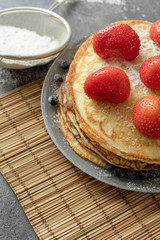 Pancakes with strawberries on a plate. Sweet breakfast or snack.