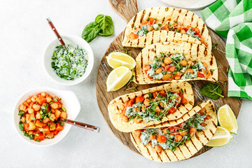 vegetarian snack of tacos with chickpea curry and sour cream sauce with parsley, spinach, green onions and sprouted flax seeds. healthy plant based food. top view on light background, flat lay - 239215911