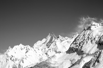 Fototapeta na wymiar Black and white snowy sunlight mountains at winter.
