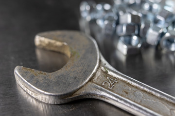 Wrench and nuts on a metal table in a workshop. Accessories for mechaics for minor mechanical repairs.