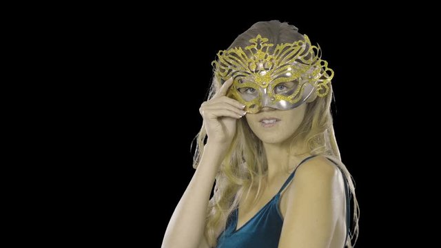 Portrait of a sexy woman who is dressing and trying on a mask, Venetian masquerade carnival mask at a party, on an isolated background, festive makeup and dress