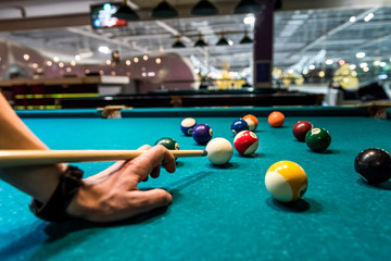 Billiard balls and hand with cue close up