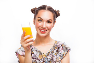 Woman drinking orange juice smiling happy excited. Beauty Teenager Model Girl. Beautiful Joyful teen girl with freckles and yellow makeup. Professional make up. Isolated on a white background
