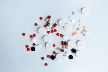 Assorted multicolored pills on white background